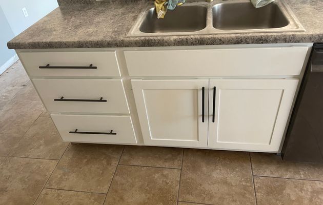 Kitchen island refinished from dark stain to bright white with black hardware