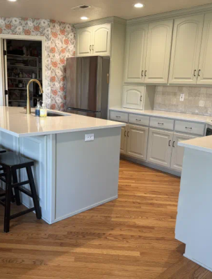 Full kitchen with sage green refinished cabinets, white countertops, and subway tile backsplash