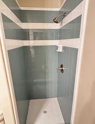 Refinished blue-gray tile shower with crisp white accent bands
