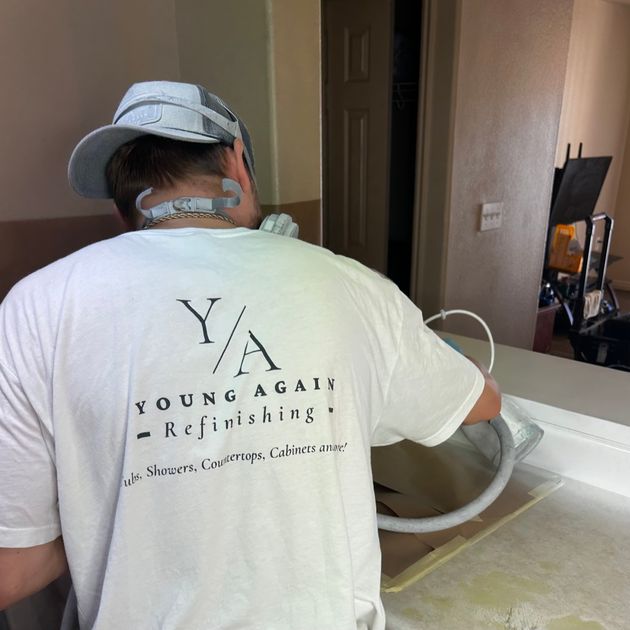Young Again Refinishing technician refinishing a tub on the job