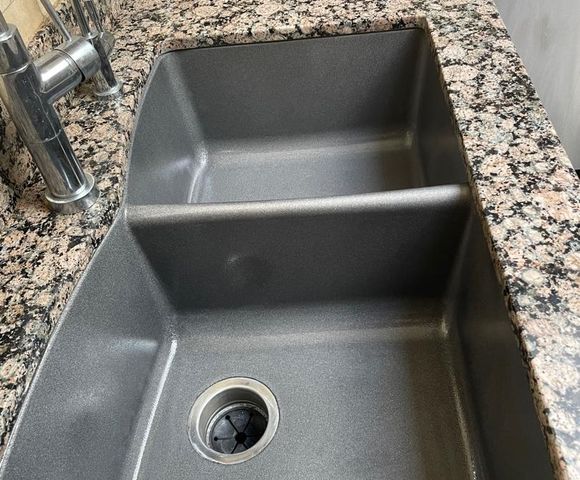 Sink refinished in dark gray set in a granite-look countertop