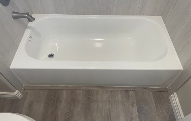 Refinished bathtub in modern gray bathroom with dark fixtures