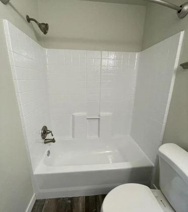 Refinished shower and tub combo with white tile surround