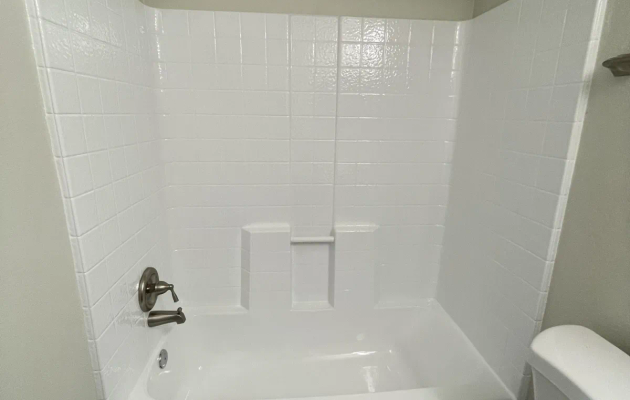 Tub and shower combo with refinished white tub and tile surround