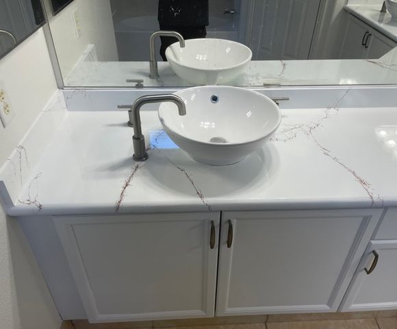 Vanity countertop refinished in a glossy white marble-vein finish with a vessel sink